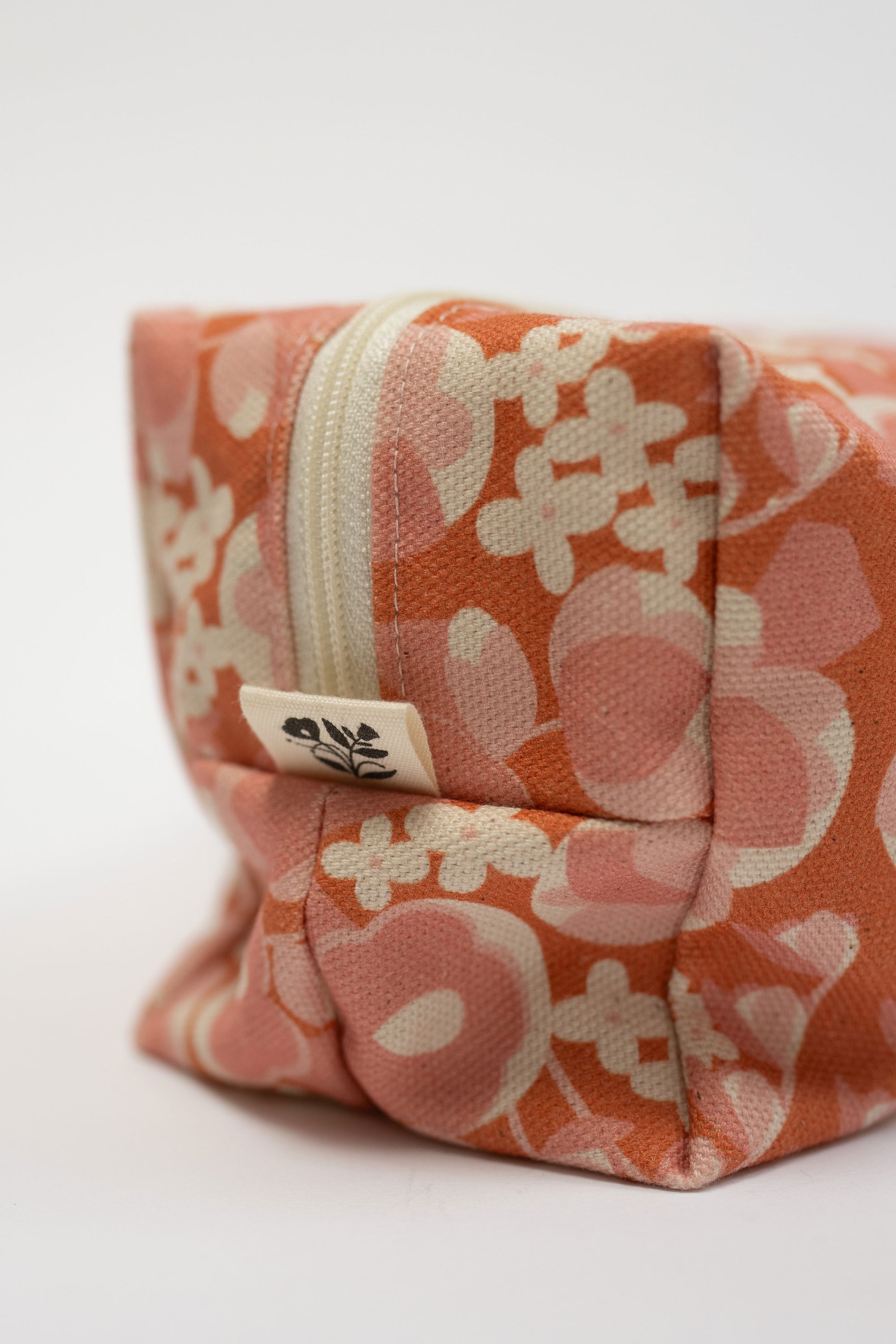 Floral-patterned fabric pouch with a zipper on a white background