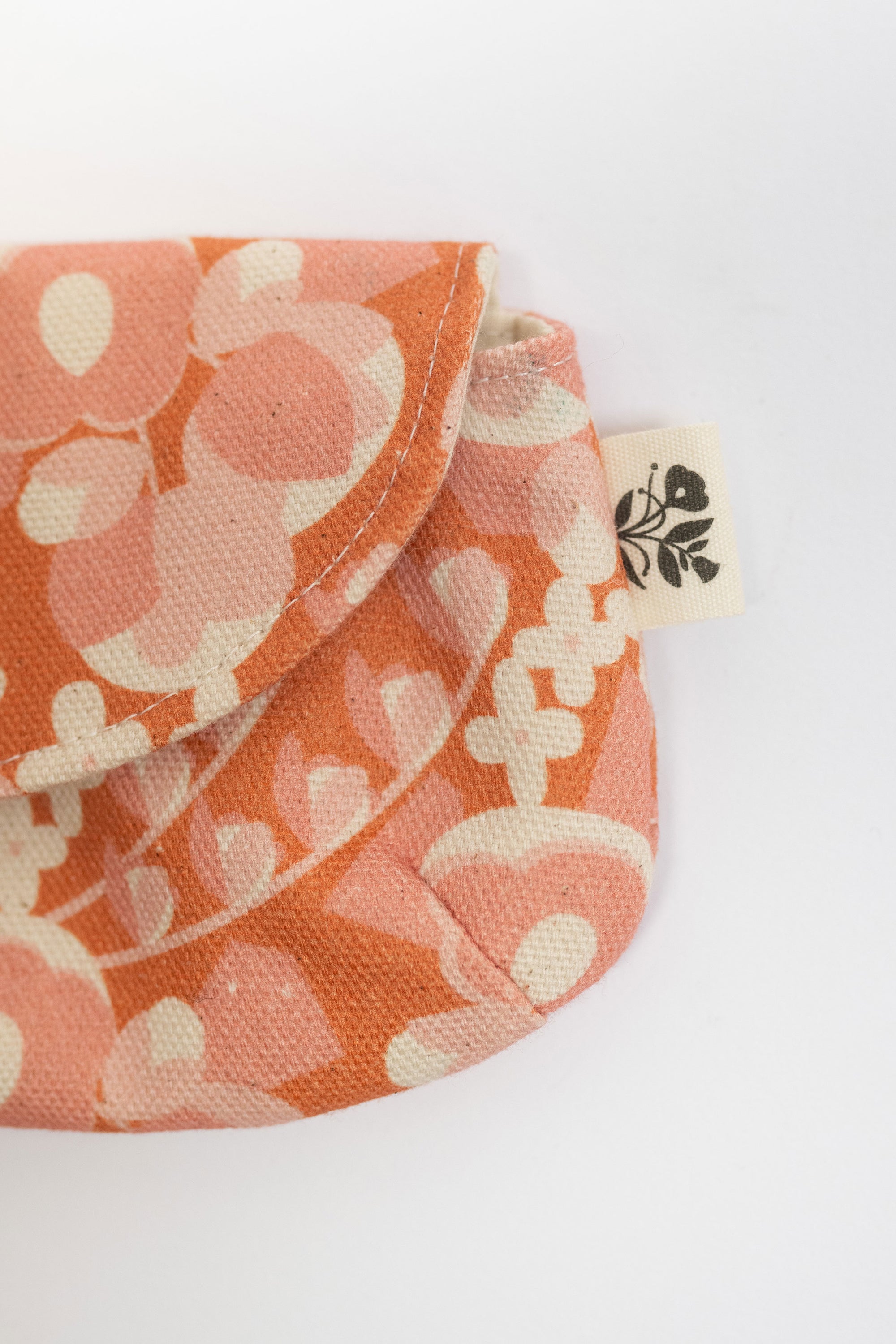 Floral-patterned pouch with a visible brand tag on a white background