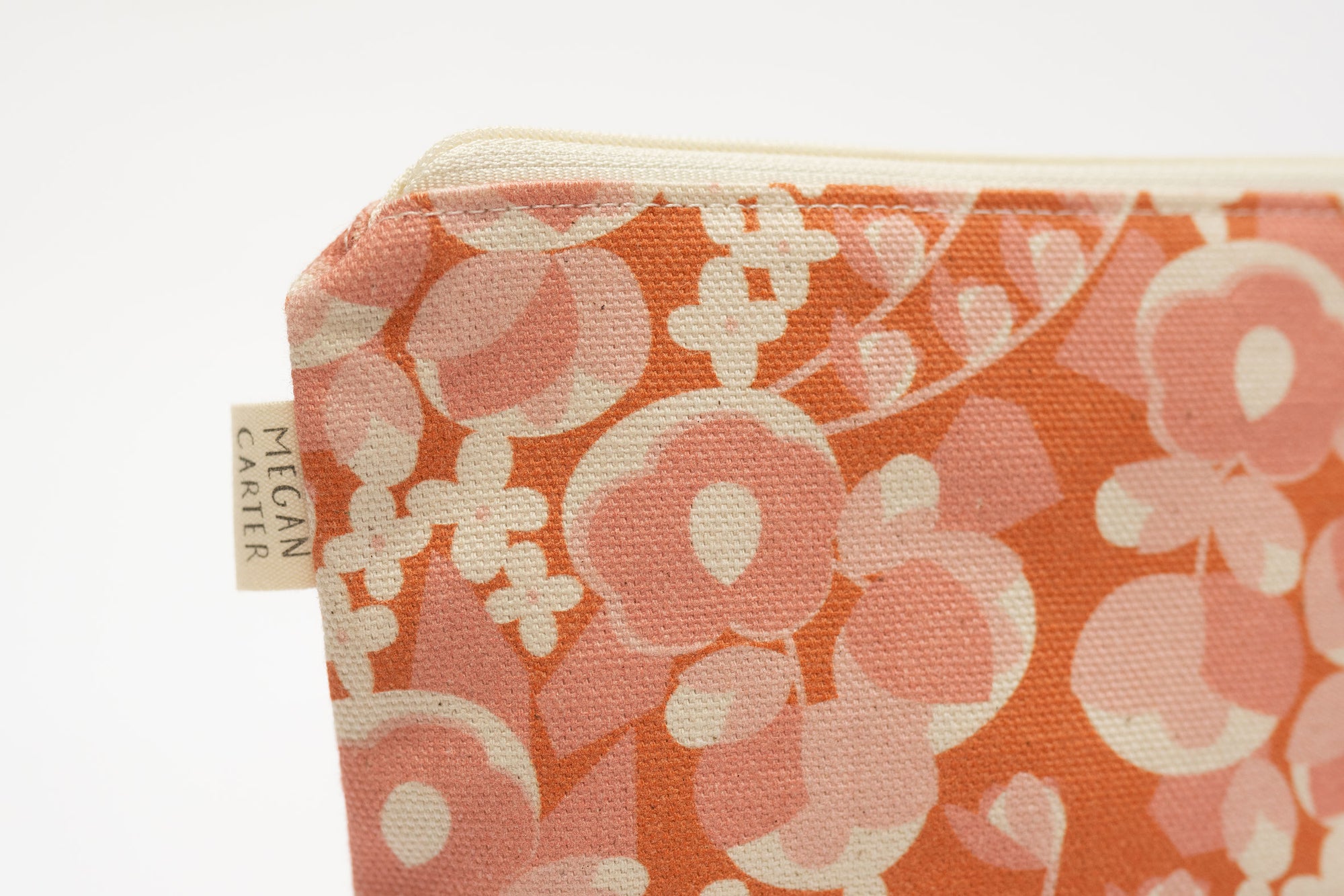 Floral patterned pouch with a visible brand tag on a white background