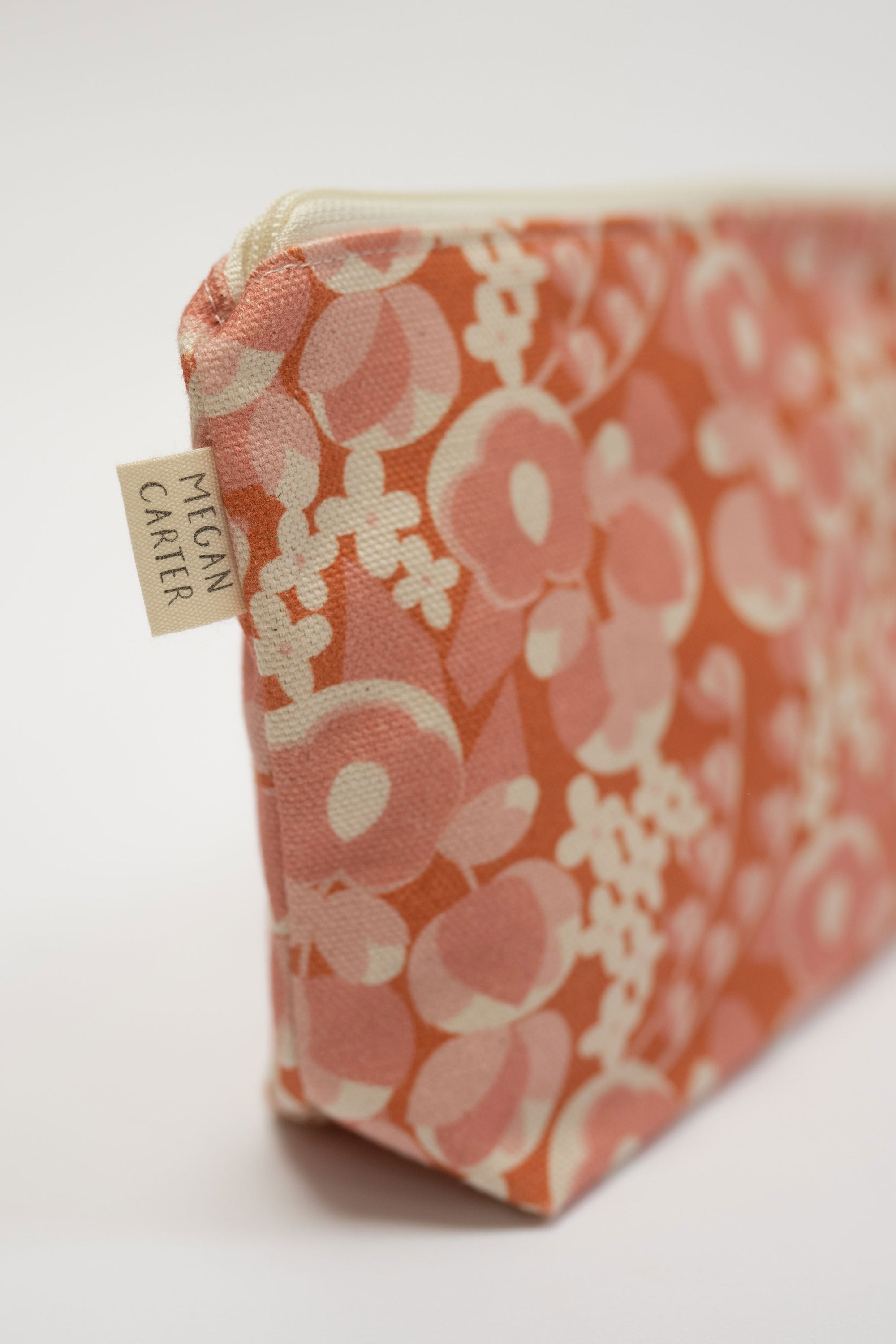 Floral patterned pouch with a visible brand tag on a white background