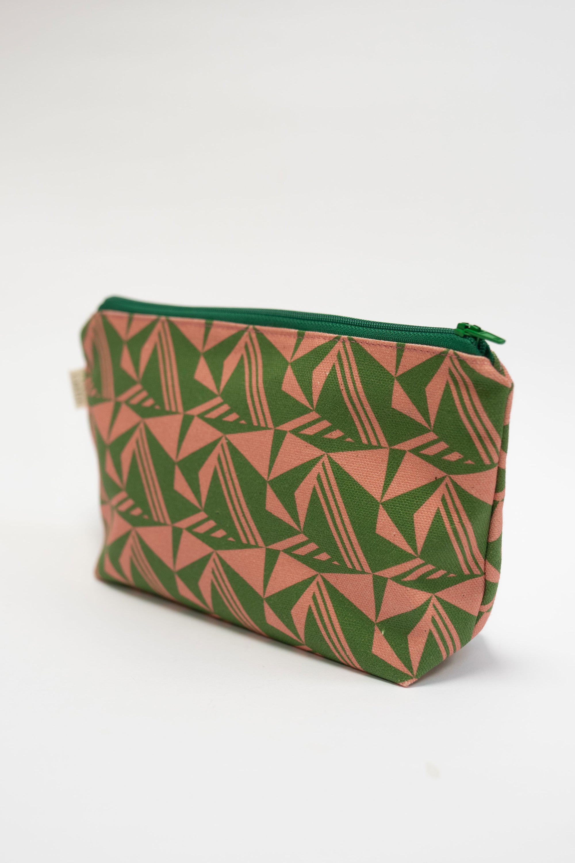 Green and pink geometric patterned pouch on a white background