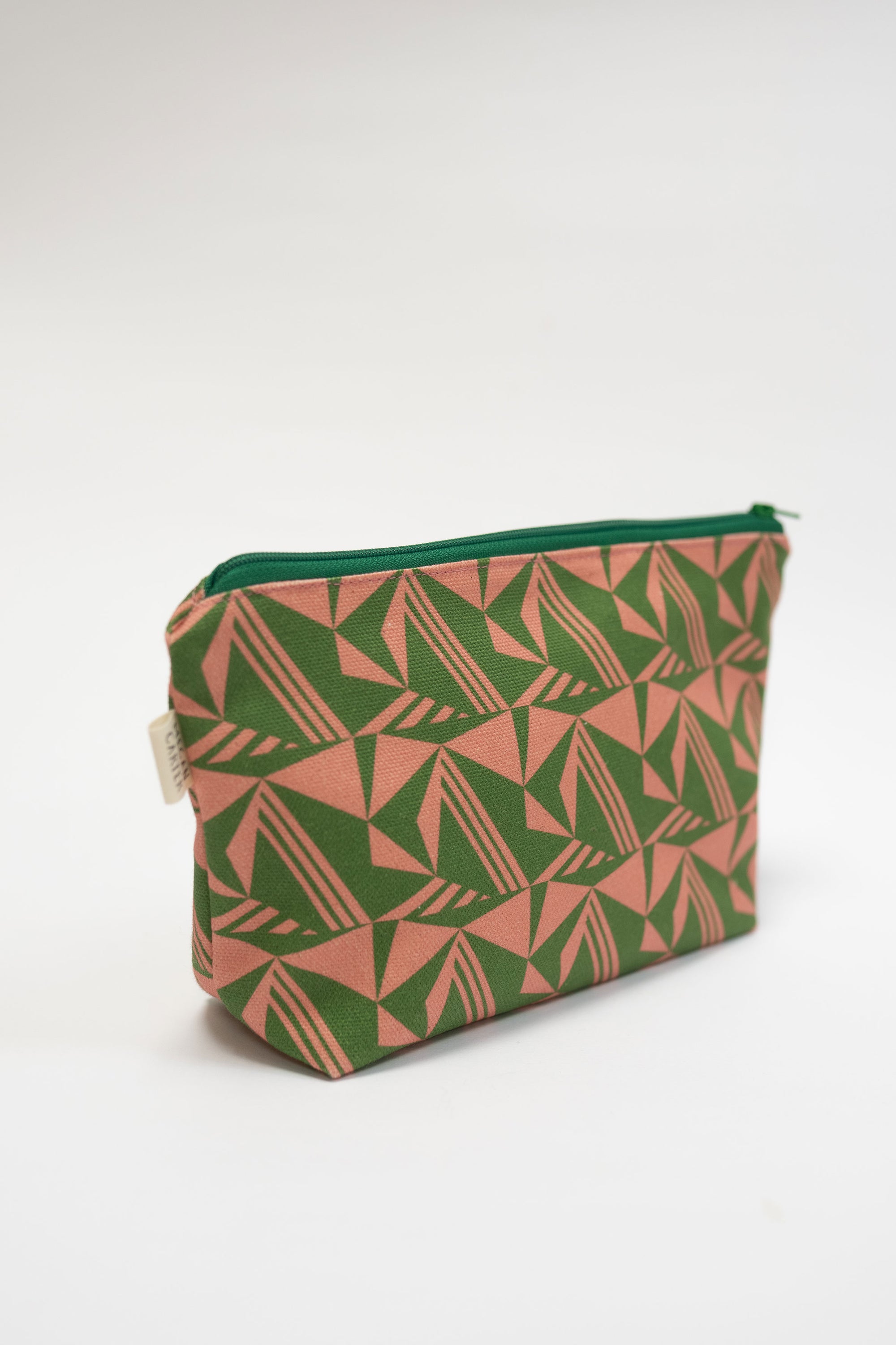 Green and pink geometric patterned pouch on a white background