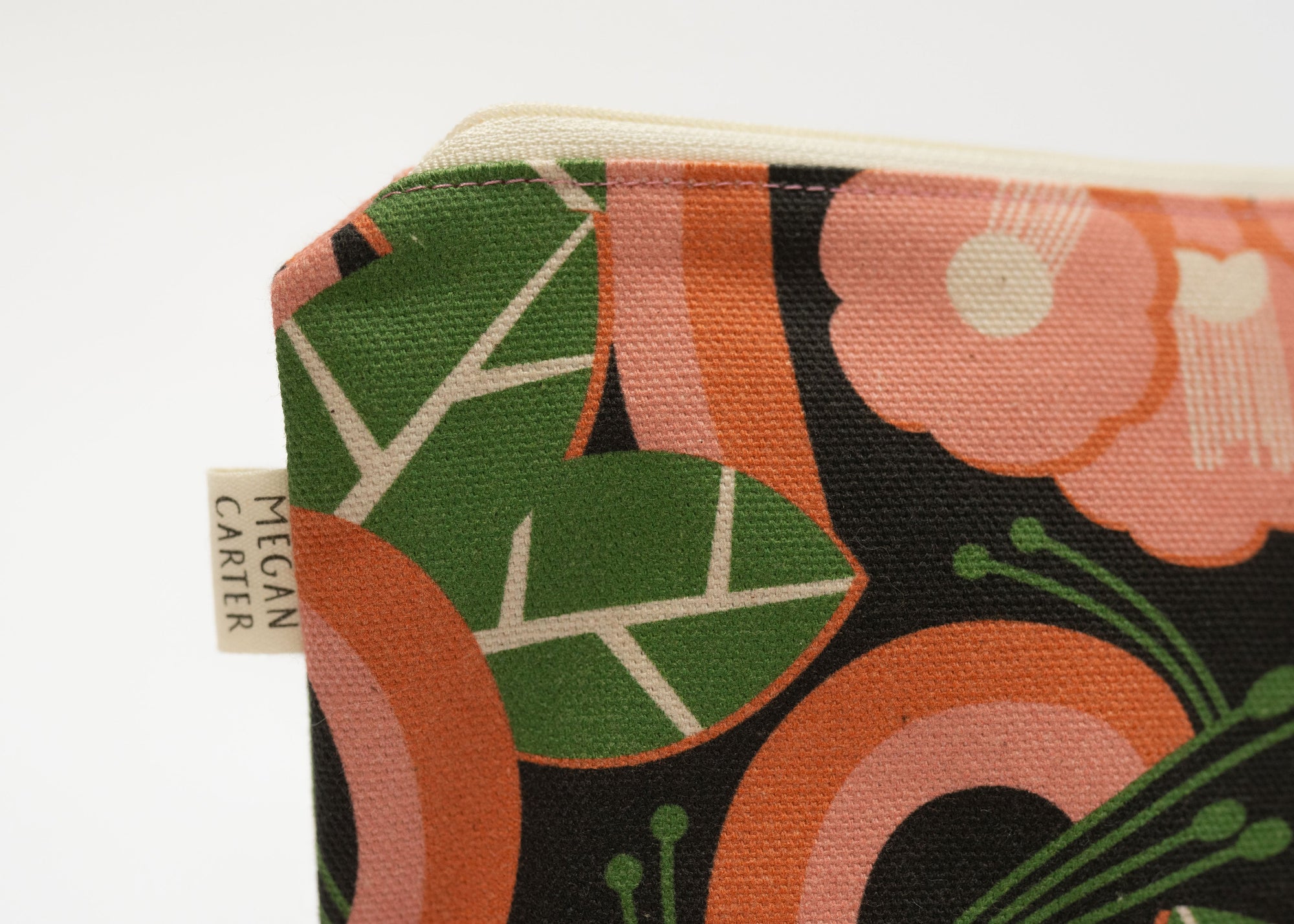 Fabric swatch with floral pattern and Megan Carter label on a white background