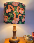 Lamp with a floral shade on a wooden table with two small vases.