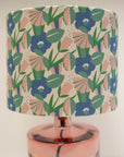 A 30cm drum lampshade with a digitally printed pattern featuring organic cotton flowers in various shades of blue and green, displayed on a lamp post.